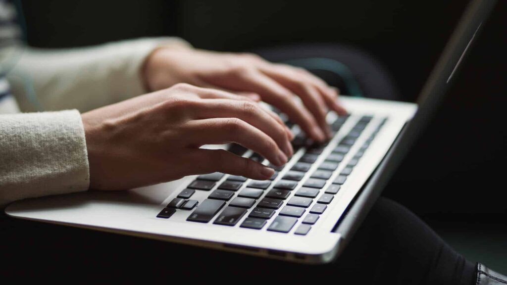 Woman typing video script on laptop